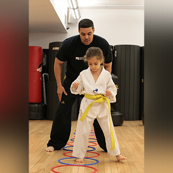 A man and young girl practicing martial arts moves.
