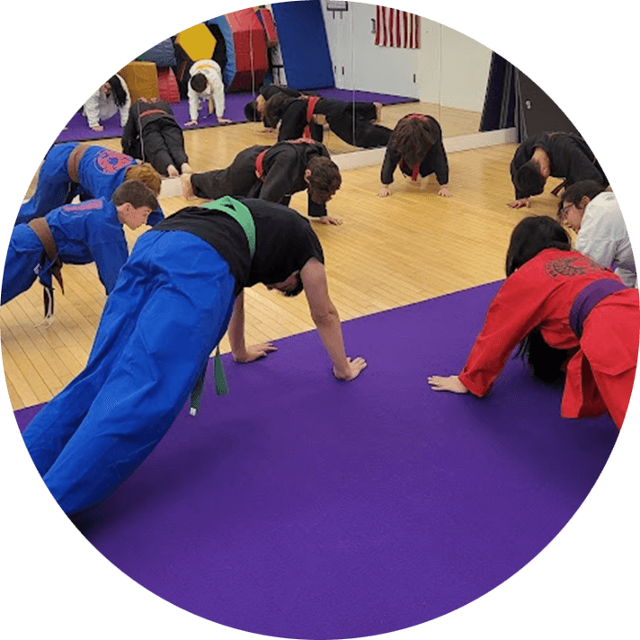 A group of people doing various positions on the floor.