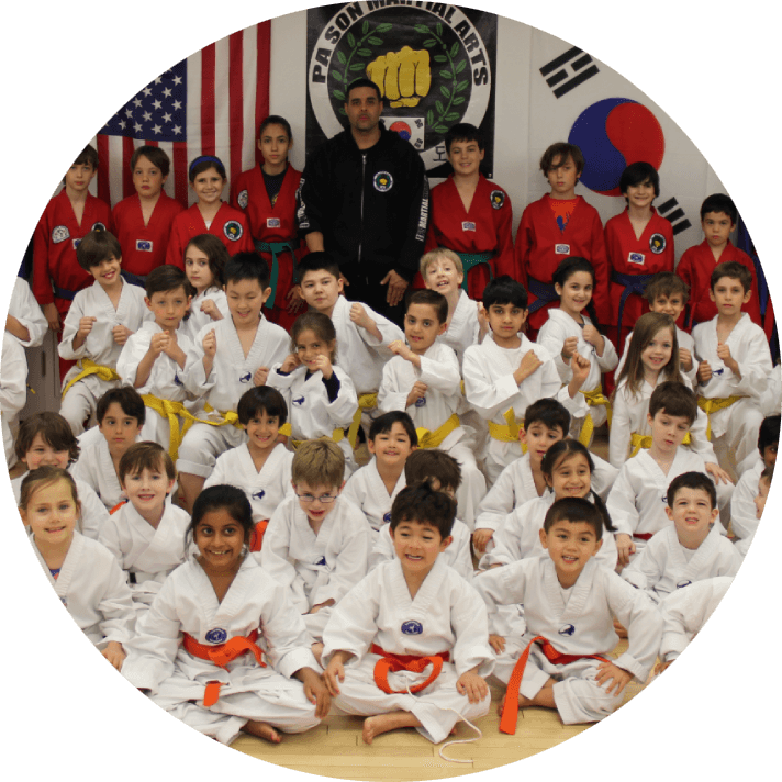 A group of young people in white uniforms and red belts.